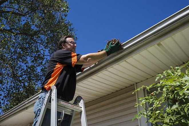 smiling worker fixing gutters on a residential home in Casselberry, FL